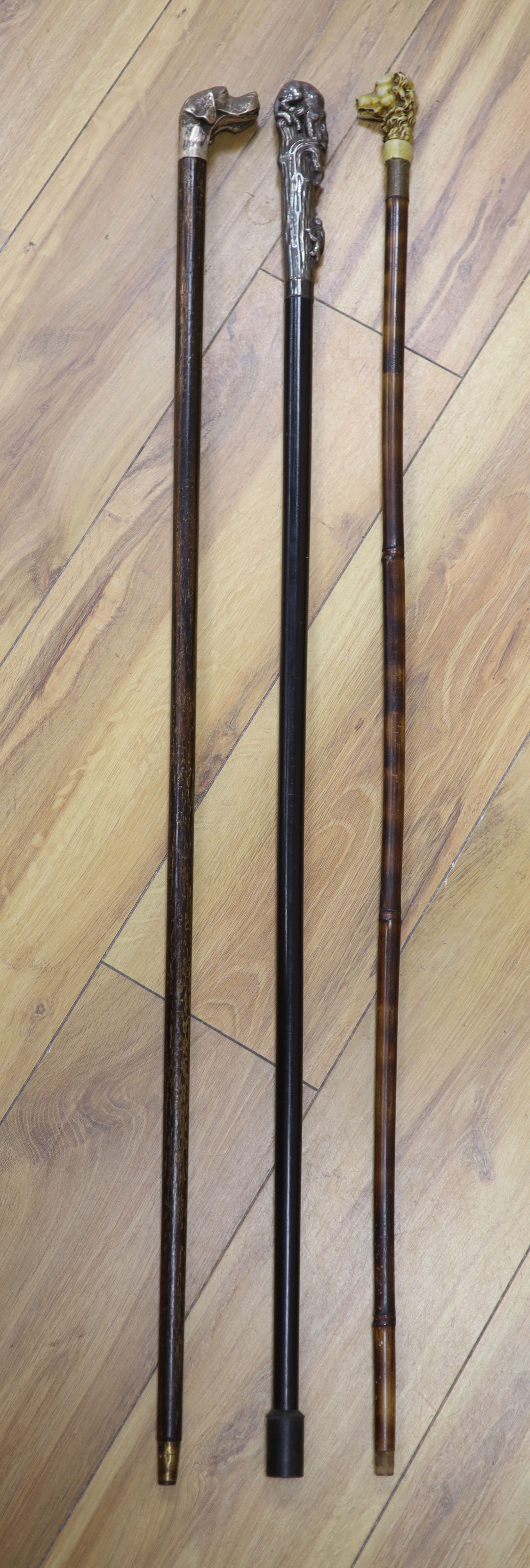 A big cat sterling-mounted cane, a dogs head 925 sterling mounted cane and a resin dogs head mounted cane